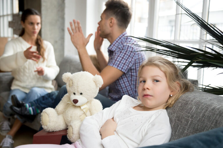 Little upset girl daughter depressed with parents arguments or d